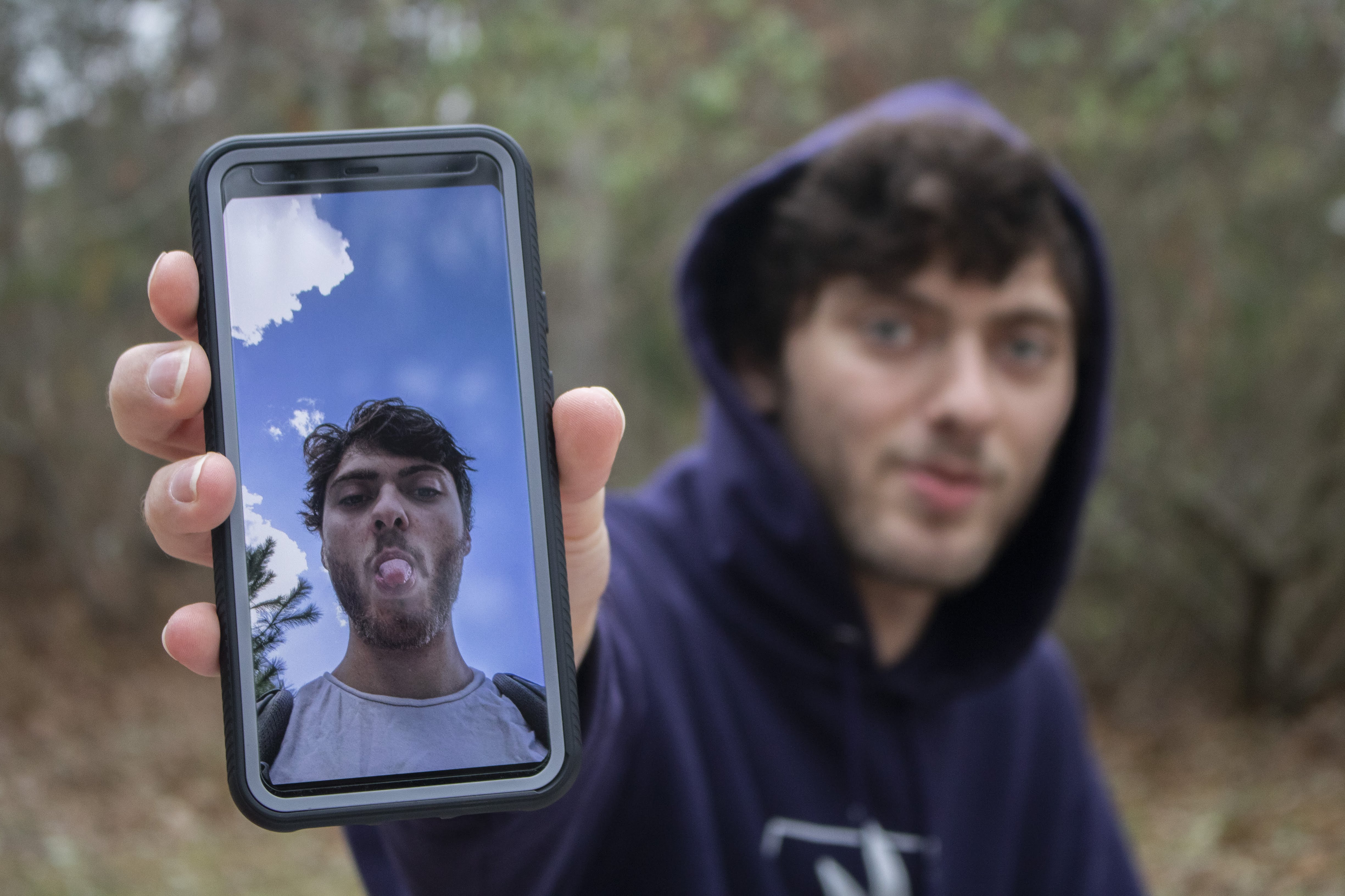 Gus showing his phone with a picture of himself